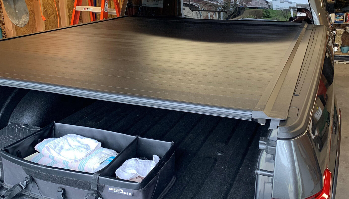 Truck bed showing storage with tonneau cover in a garage